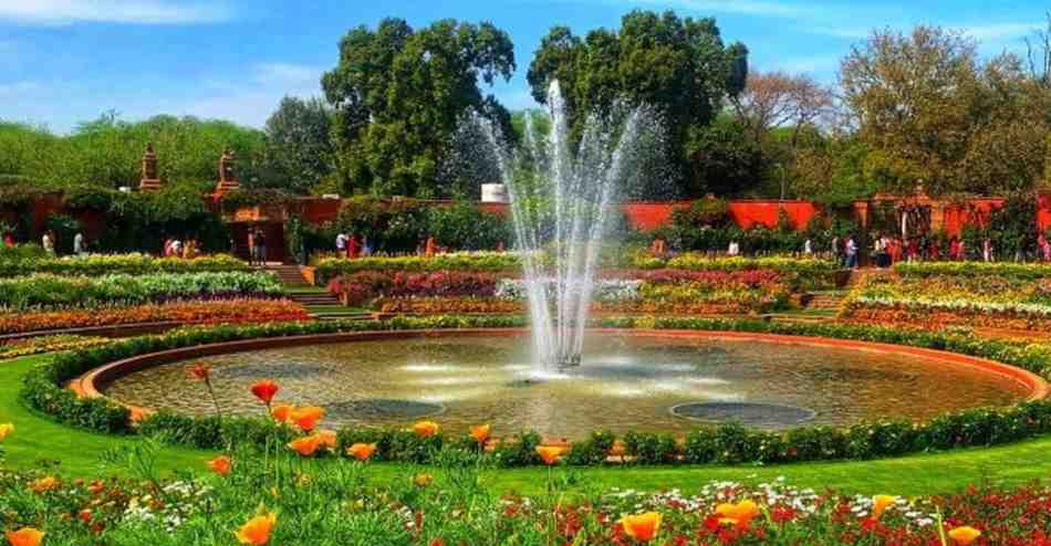 Panoramic view of a serene Mughal garden featuring a domed structure with central canal fountains and neatly arranged flowers and trees on both sides